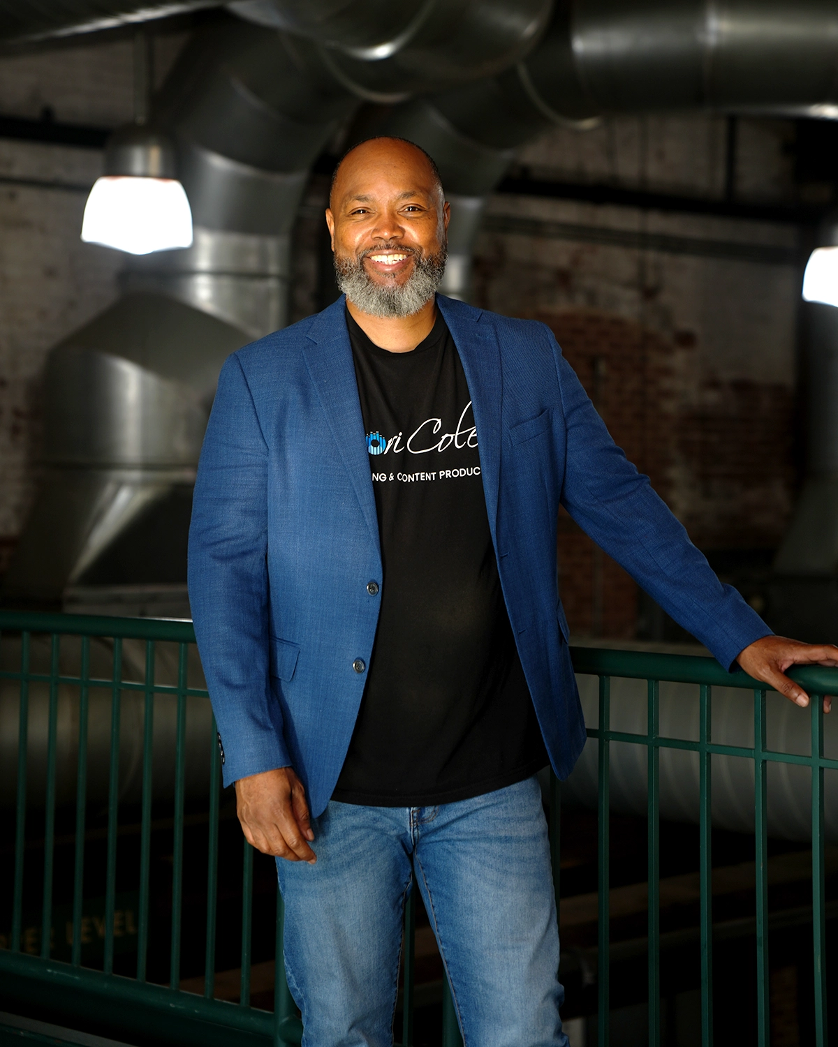 Samori Coles smiling in a blue blazer over a Samori Coles branded tee